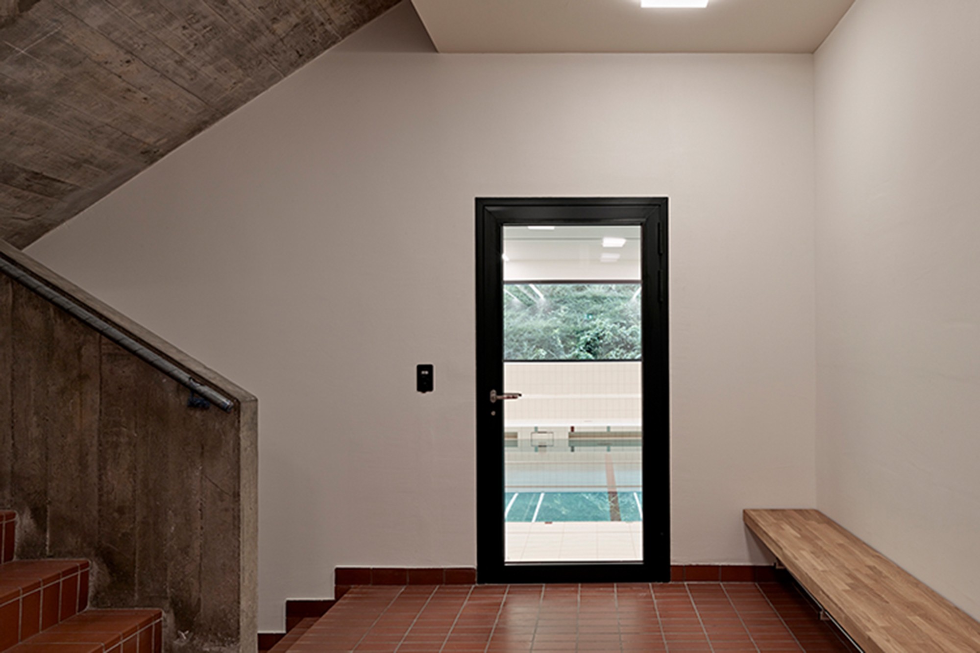 Dank neuer, verglaster Türe, ist eine Blickbeziehung zwischen Schulhaus und Schwimmhalle entstanden. (Foto: © Roland Bernath, Zürich)